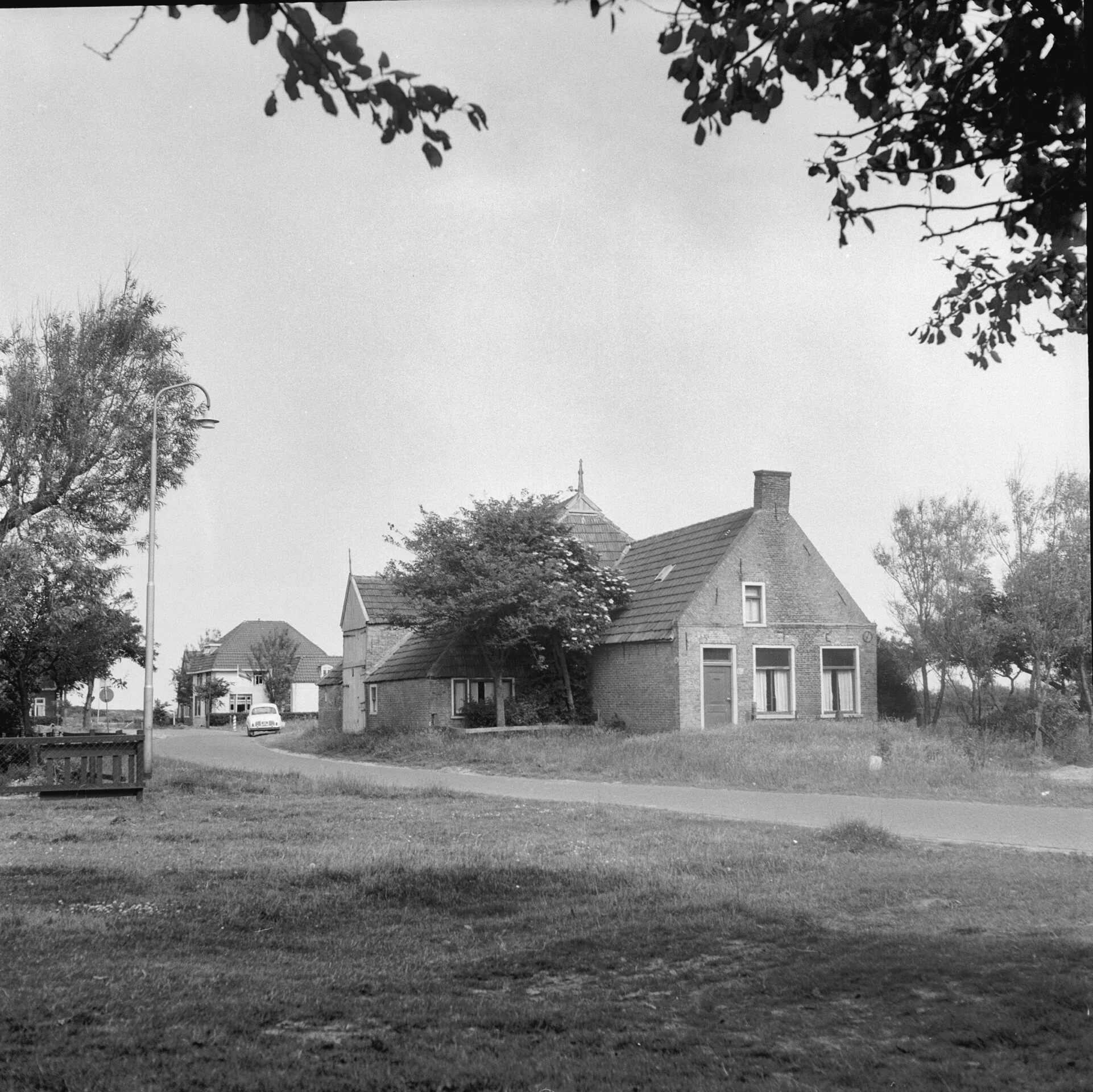 Historische foto van Hoorn met zicht op weg en naastgelegen boerenerf.